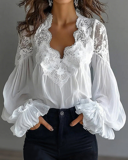White V-neck blouse with lace trim and ruffled cuffs, hands in dark jeans pockets, close-up crop 1