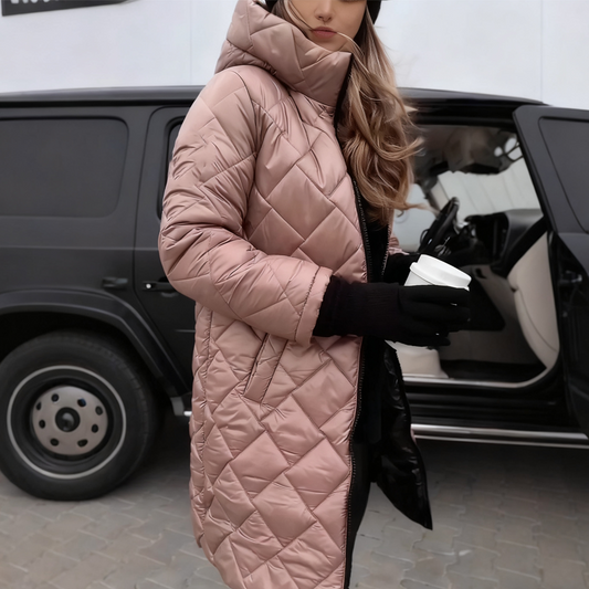 Woman in a dusty pink diamond-quilted hooded long coat, holding a takeaway coffee in black gloves beside a black car. 1