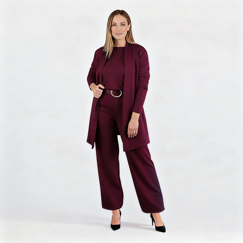 Full-length studio shot of a model in the burgundy set with belt and black heels, one hand holding the open cardigan. 13