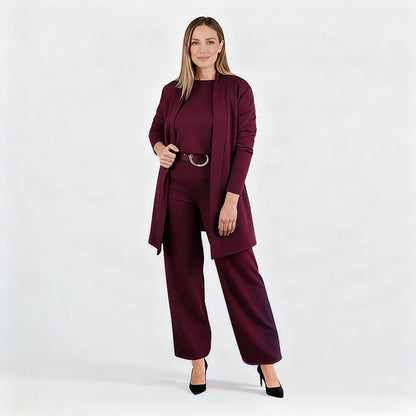 Full-length studio shot of a model in the burgundy set with belt and black heels, one hand holding the open cardigan. 13