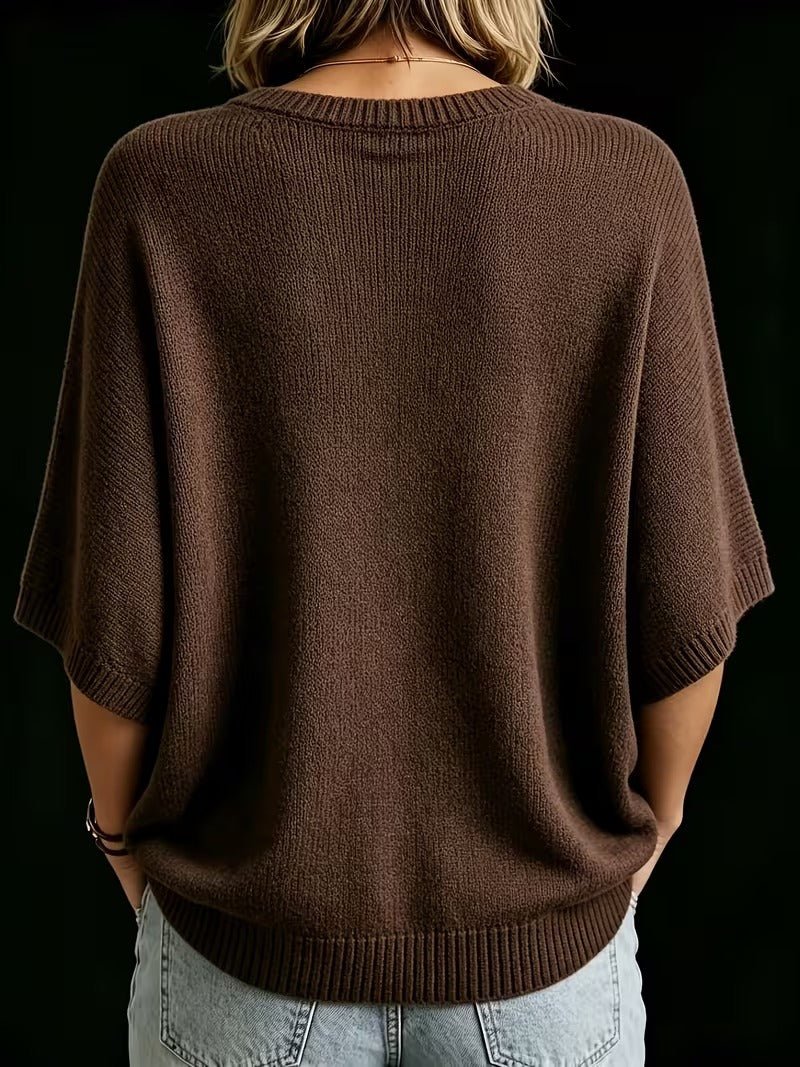 Back view of the brown knit batwing top worn with light jeans, showing ribbed round neckline, cuffs and hem. 21
