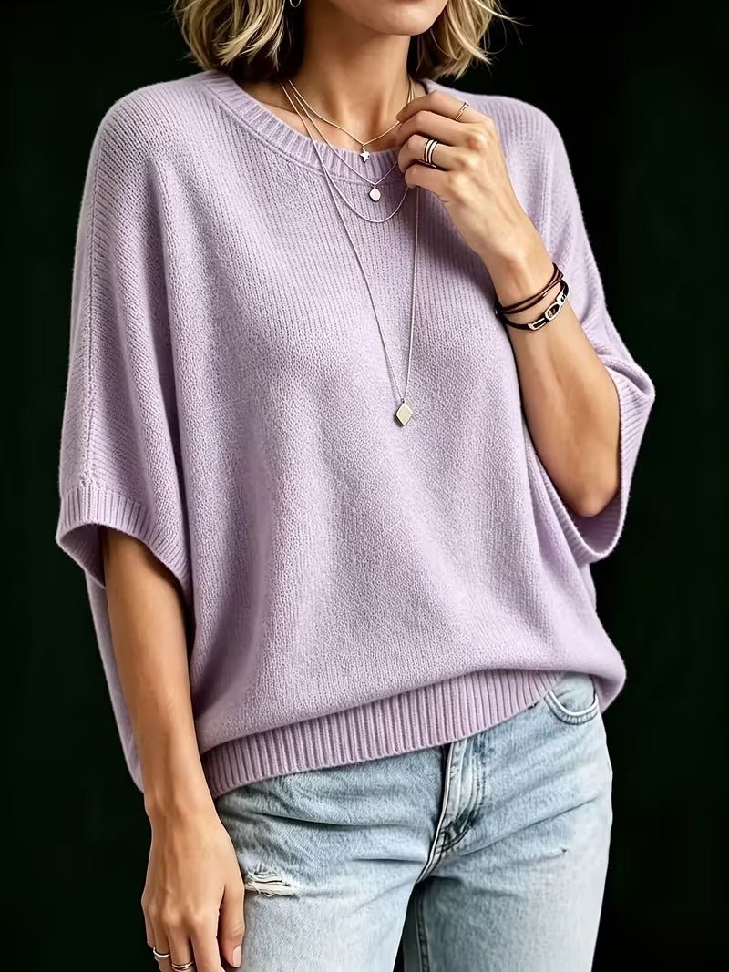 Lilac knit top worn by a model with light jeans, showing the loose batwing sleeves and ribbed round neckline. 8