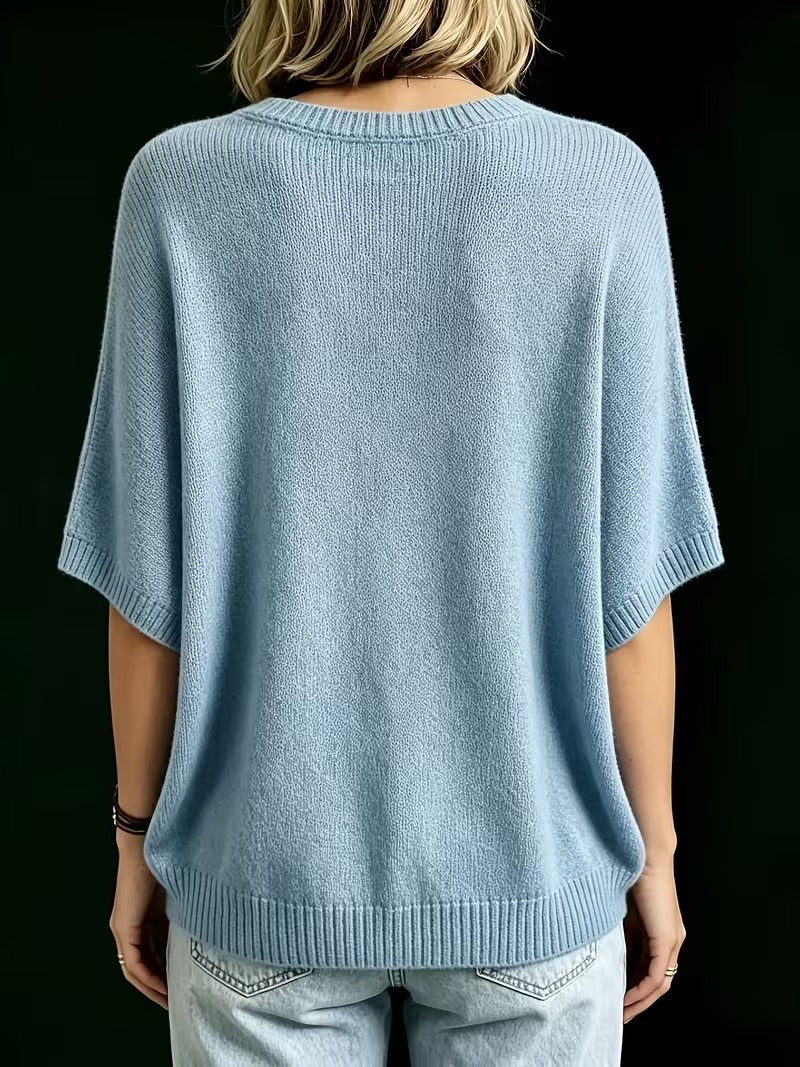 Back view of the light blue knit top, showing the ribbed round neck, short batwing sleeves and ribbed hem. 14