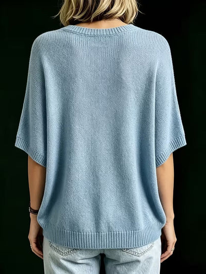 Back view of the light blue knit top, showing the ribbed round neck, short batwing sleeves and ribbed hem. 14