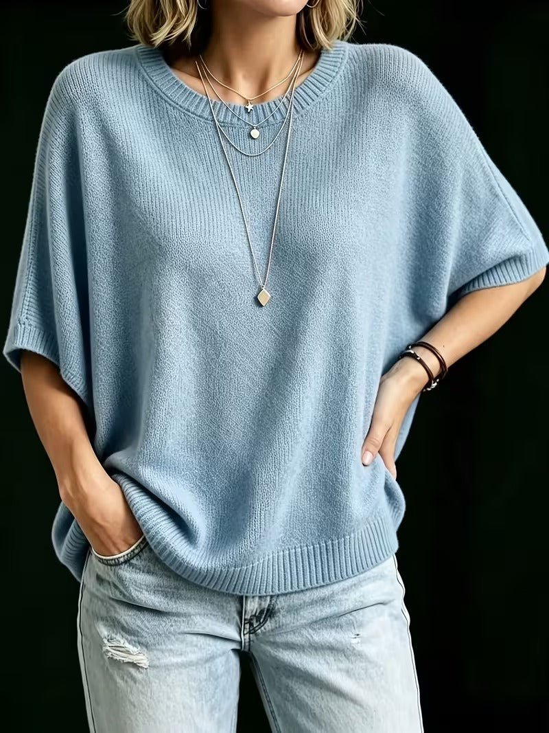 Light blue knit top worn with one hand in a jeans pocket and the other on the hip. 15