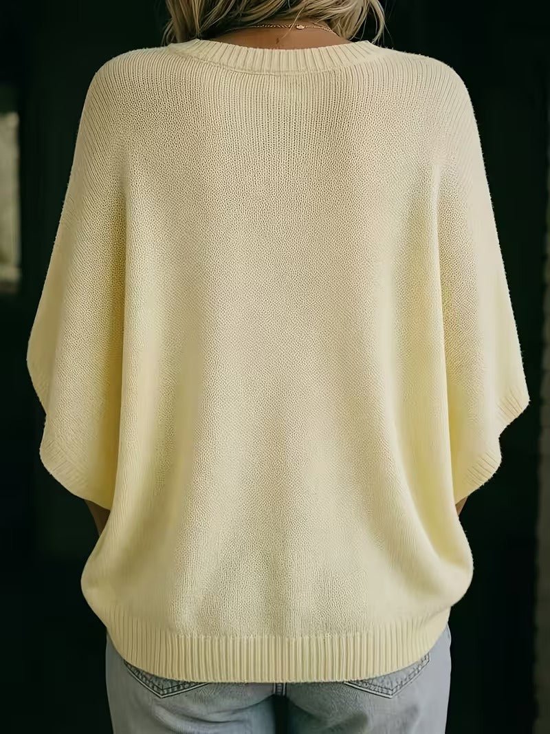 Back view of the pale yellow knit top, showing the wide batwing sleeves and ribbed hem. 6