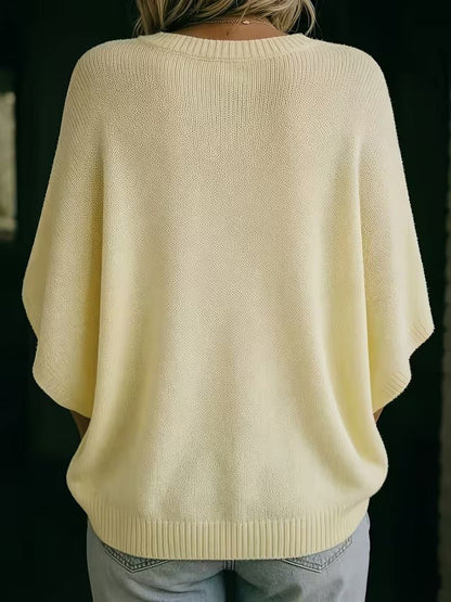 Back view of the pale yellow knit top, showing the wide batwing sleeves and ribbed hem. 6