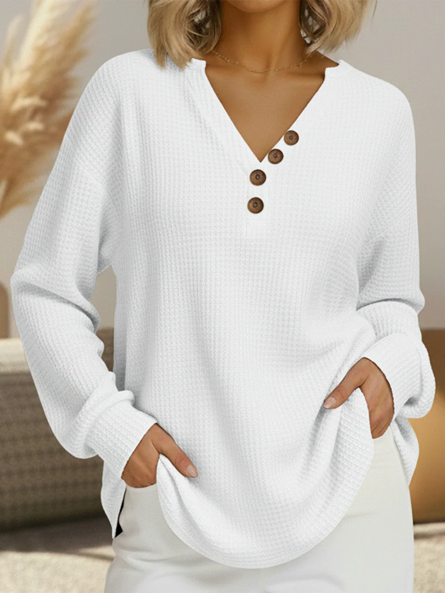 White waffle knit V-neck jumper with four brown buttons along one side of the neckline 12