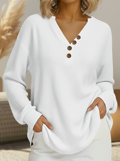 White waffle knit V-neck jumper with four brown buttons along one side of the neckline 12