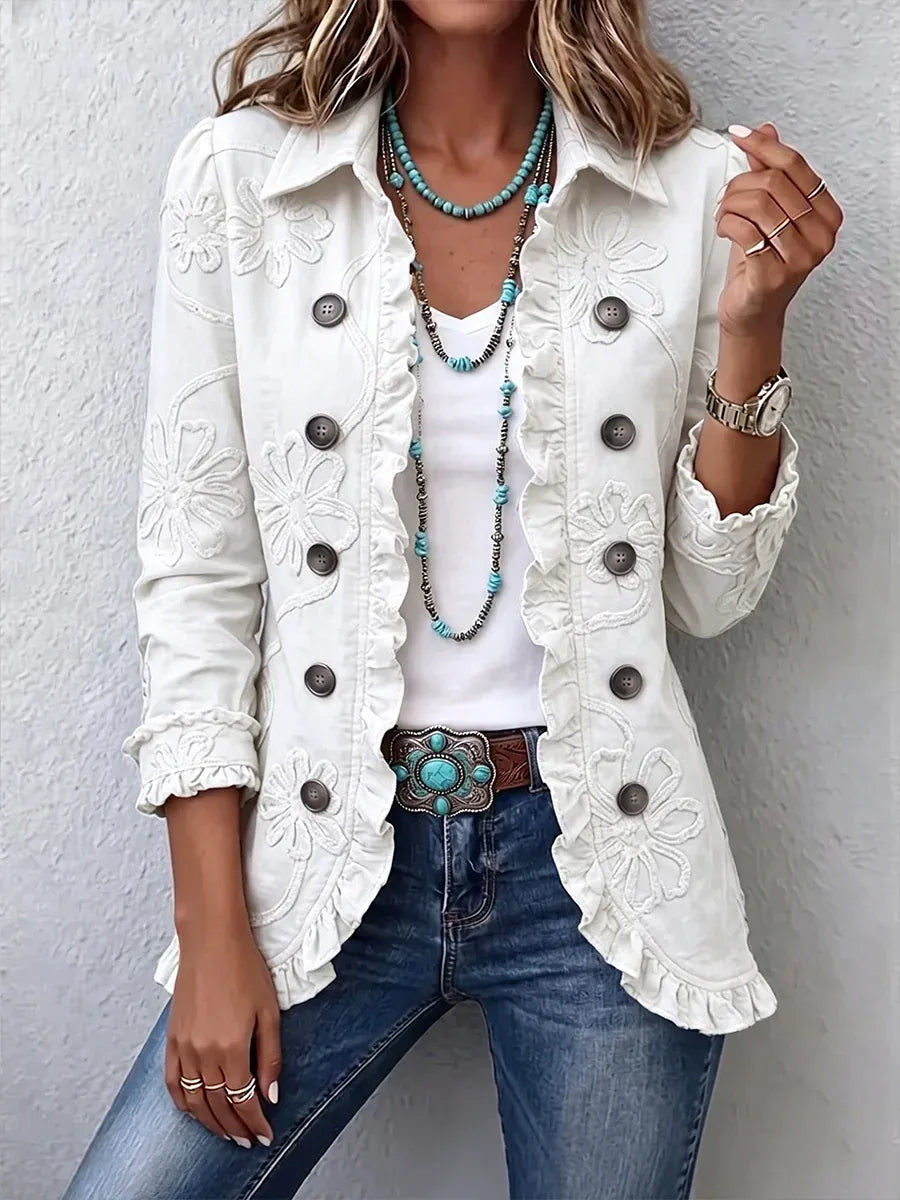 White version of the jacket with tonal floral embroidery and ruffled trim, worn over a white top with a turquoise belt buckle. 8