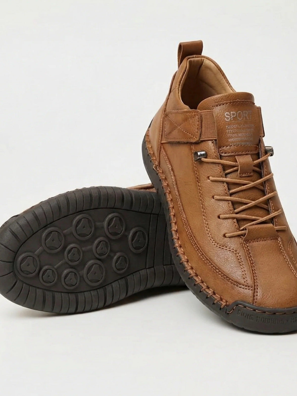 Tan brown trainers with matching laces and a dark brown sole, one shoe showing the studded tread 6