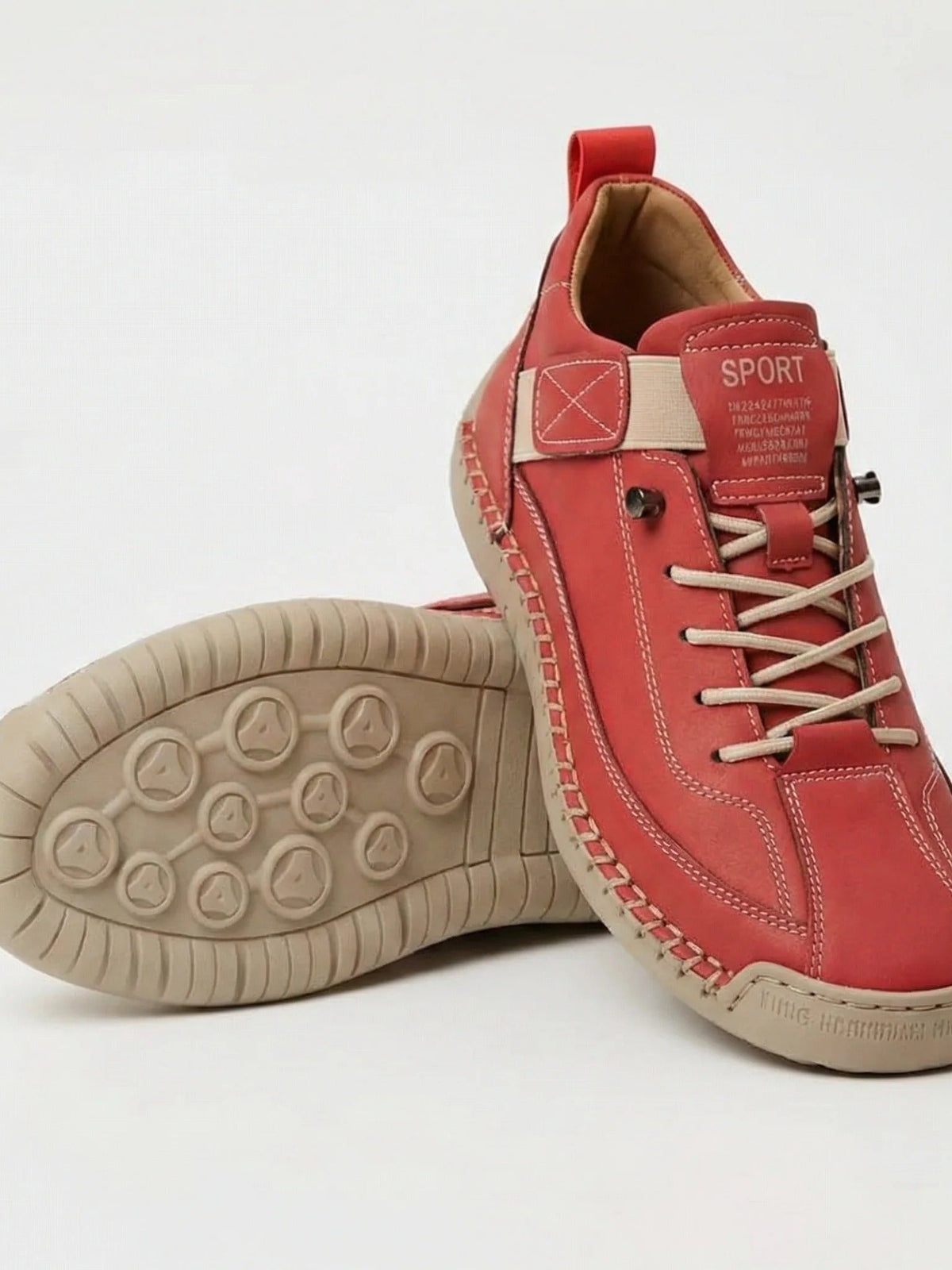 Red trainers with cream laces and strap and a beige sole, one shoe showing the studded tread 10