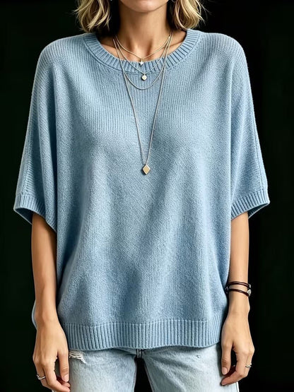 Front view of the light blue knit top on a model standing with arms relaxed, showing the ribbed cuffs and hem. 16