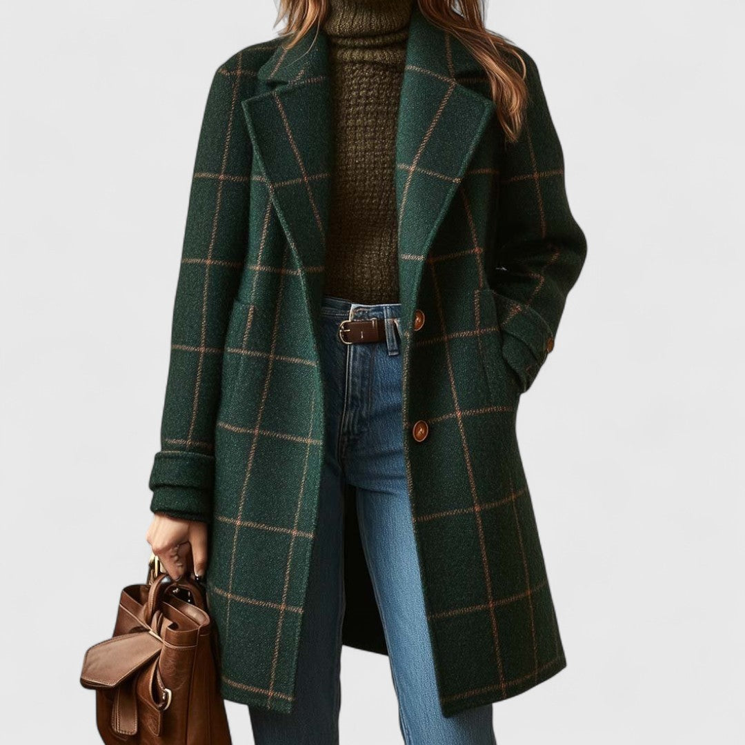 Model wears the dark green checked coat open over a brown knit roll-neck and jeans, holding a tan leather bag. 1