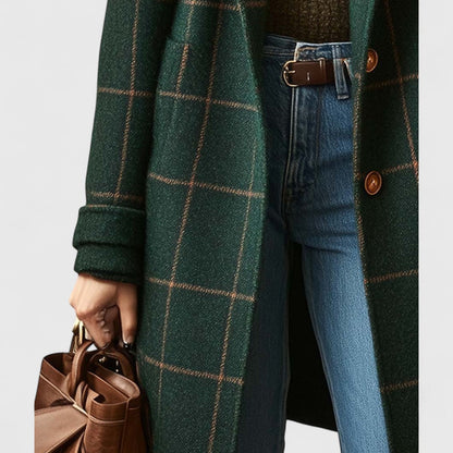 Detail of the coat's left side with patch pocket and turned-back cuff, worn with jeans, a brown belt and a leather bag. 4
