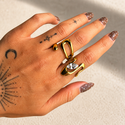 Open gold-tone ring worn on a finger alongside a second gold ring set with a marquise-cut stone 4
