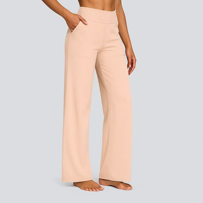 Side view of the high-waist straight-leg trousers in soft peach, worn by a barefoot model with a hand in the pocket. 14