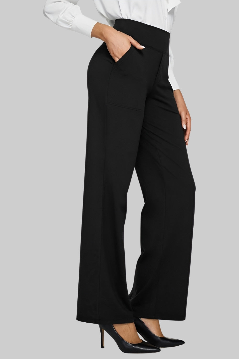 Black high-waist trousers styled with a white button-up shirt and black pointed high heels, hand resting in the side pocket. 10