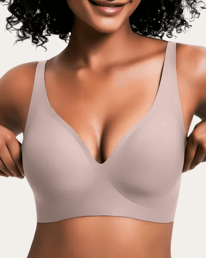 Model wearing the seamless V-neck bra in a plain soft taupe pink shade, front view. 10