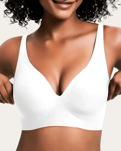 Model wearing the plain white seamless V-neck bra, shown from the front with hands at the sides. 7