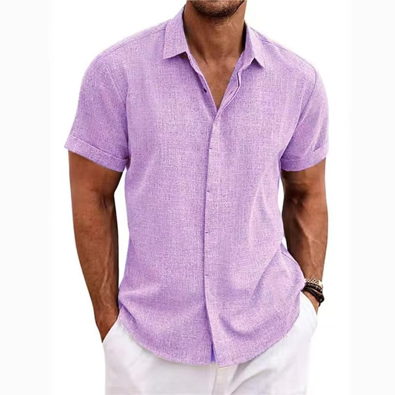 Lilac textured short-sleeved shirt with a collar and rolled cuffs, worn by a model with white trousers. 10