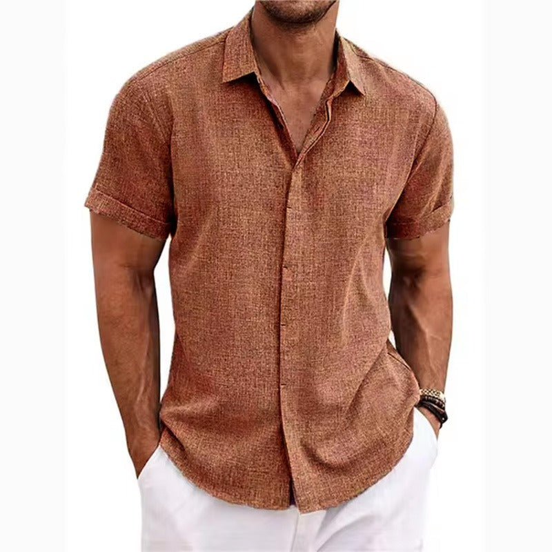 Rust brown textured short-sleeved shirt with a collar and rolled cuffs, worn by a model with white trousers. 13