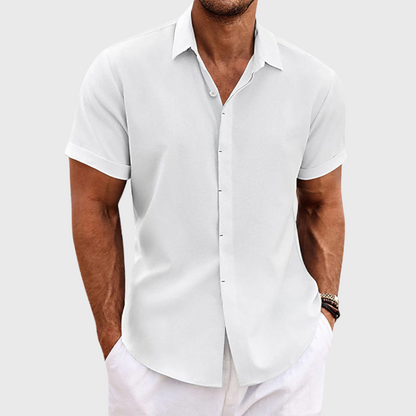 White short-sleeved shirt with a smooth finish and rolled cuffs, worn by a model with white trousers. 3