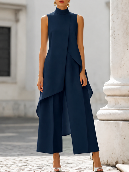 Navy version on a model, front view, showing the sleeveless asymmetric top and full-length wide-leg trousers outside a white building. 6