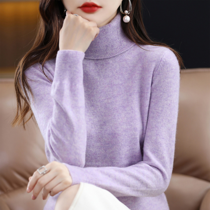 Model in the roll neck jumper in soft marled lilac, resting her chin on her hand while seated. 6