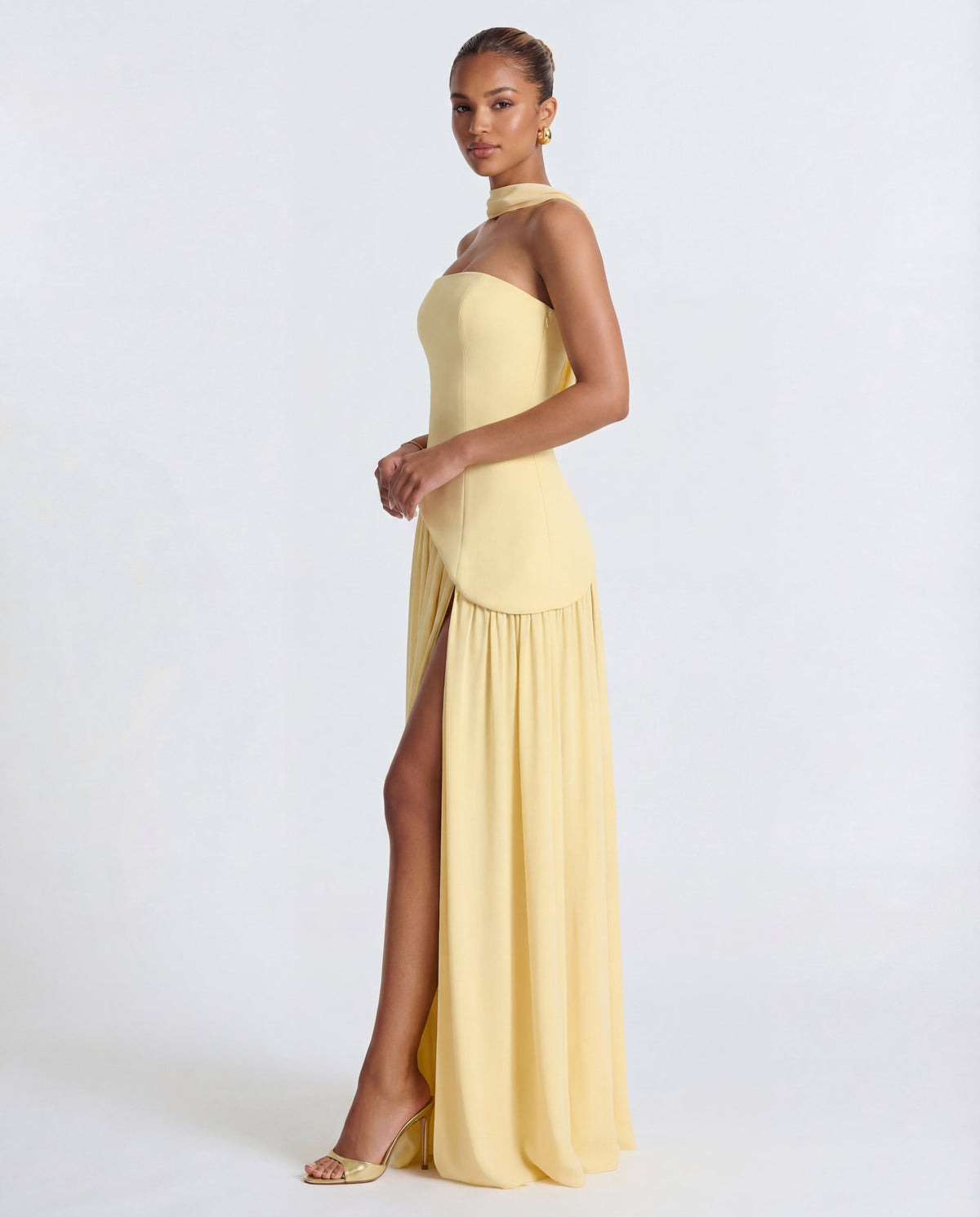 Side view of pale yellow strapless maxi dress showing curved panel at the waist and side slit 7