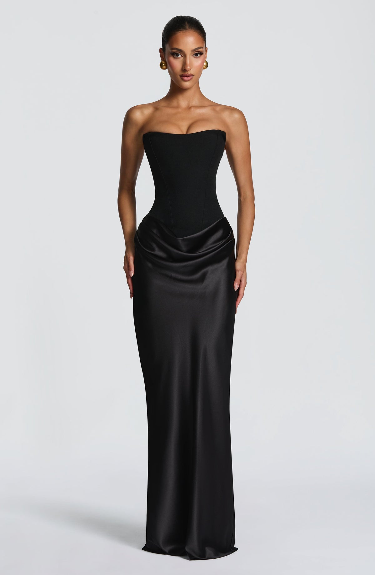 Front view of the black strapless corset maxi dress with draped satin skirt, on a grey background 23