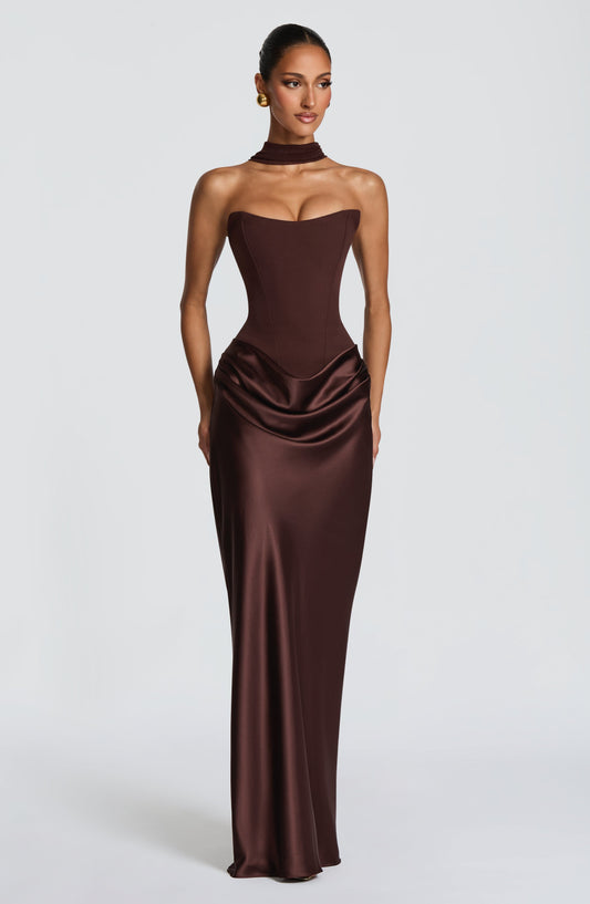 Model faces the camera in the brown strapless corset maxi dress with a matching neck scarf 1
