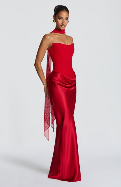 Red corset dress with a sheer scarf draped around the neck and trailing down one side 13