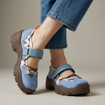 Light blue suede shoes with plaid panels, pink accents, a strap and chunky brown soles, worn with cropped blue jeans. 3