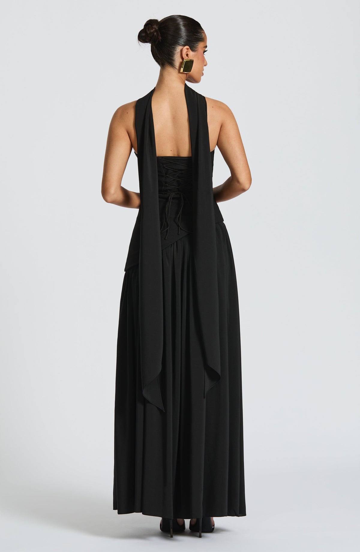 Back view of black maxi dress with scarf draped down the back above lace-up corset detail 9