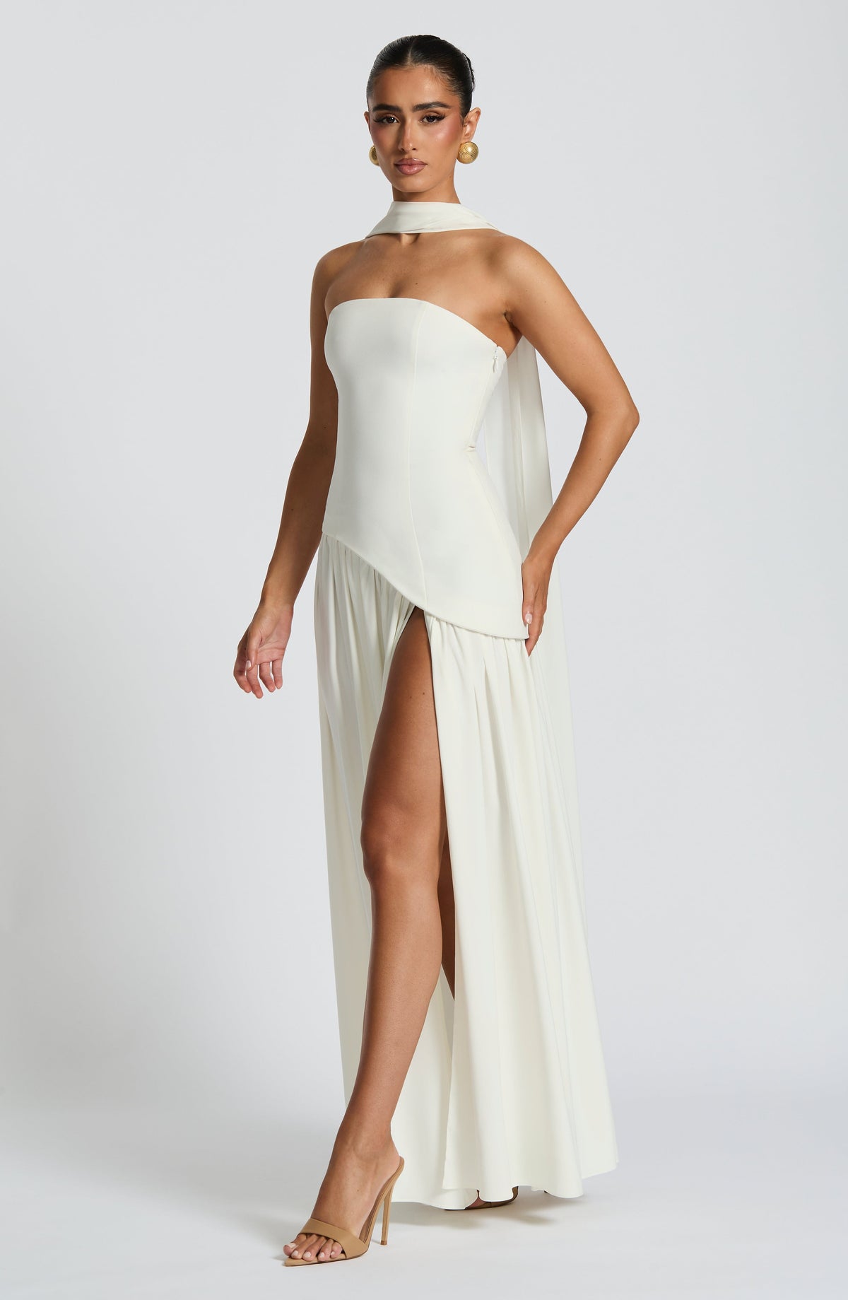 Cream dress seen from the side, with a high slit and scarf draped behind the shoulder 35