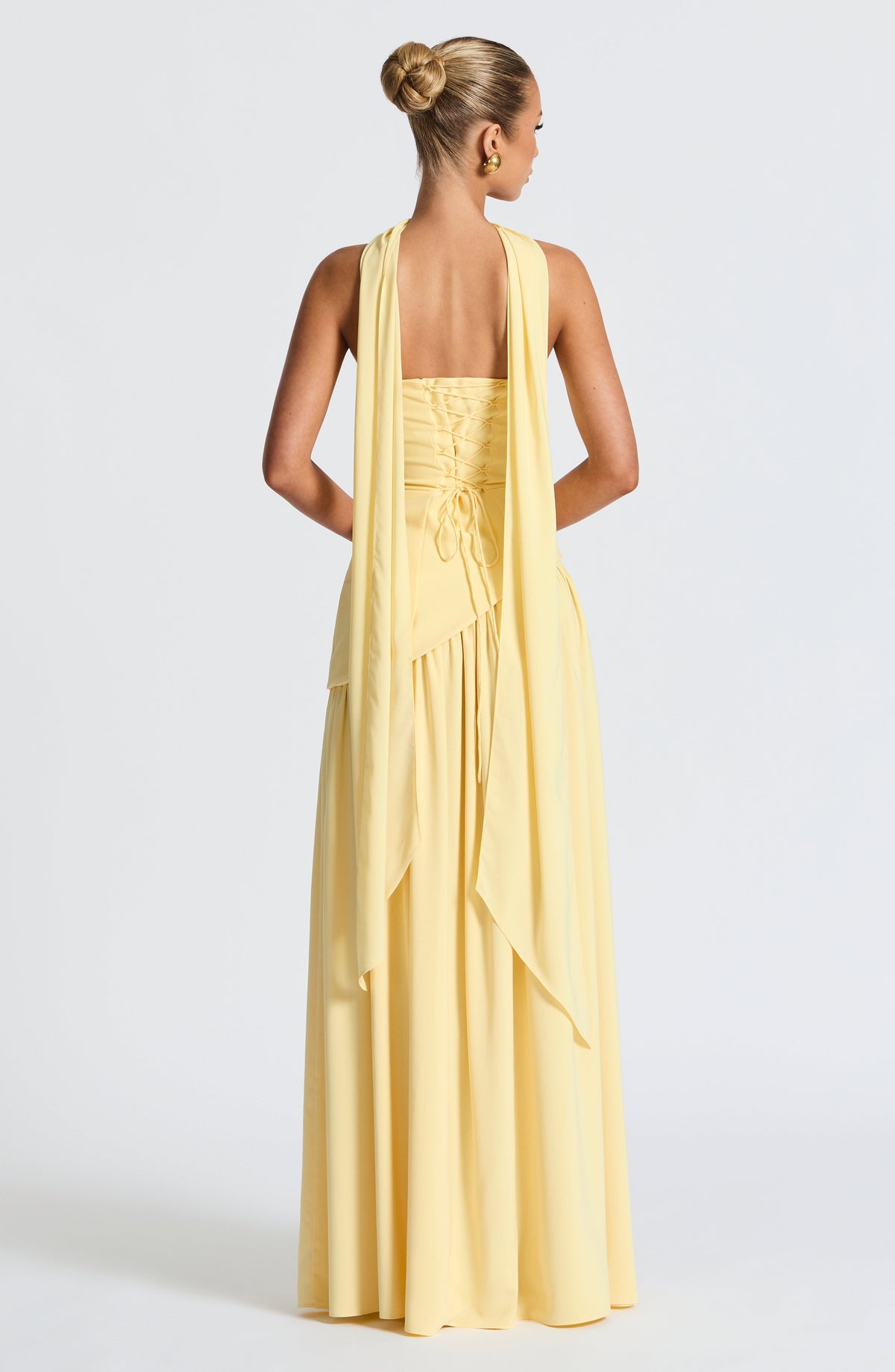 Back view of the pale yellow dress, showing the lace-up corset back and scarf panels draped down the back. 4