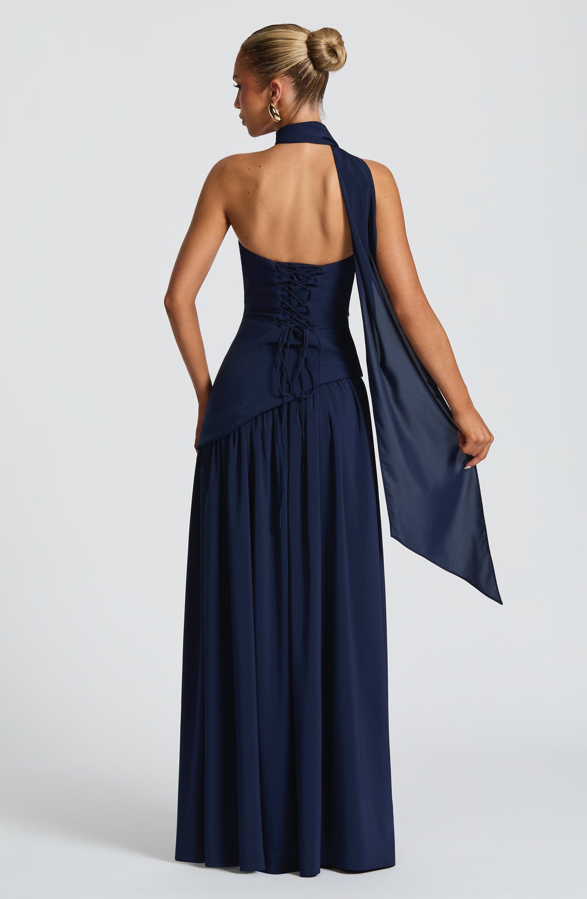 Back view of navy maxi dress with lace-up corset back and scarf draped over one shoulder 12