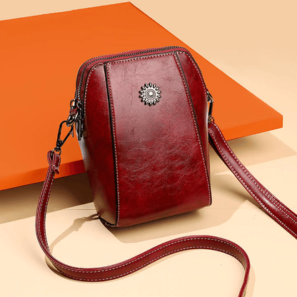 Burgundy version at an angle against an orange panel, with its stitched strap trailing 7