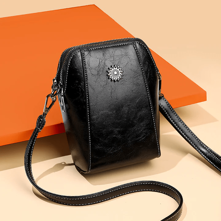 Black version at an angle against an orange panel, with its long strap curving forward 6