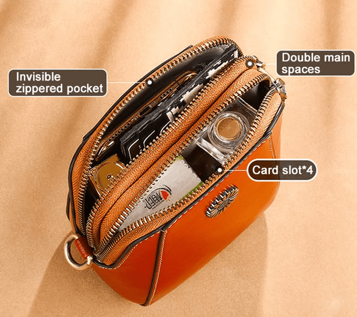 Top view of the open tan bag showing two zipped compartments, card slots and a phone inside 10