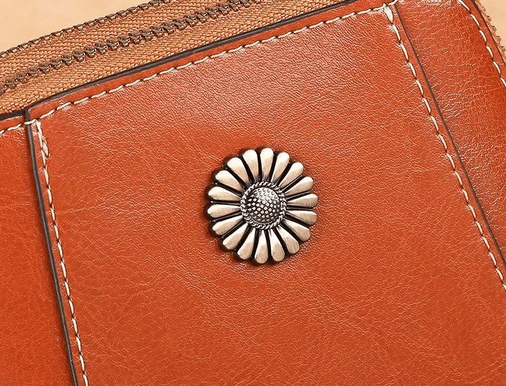 Close-up of the silver daisy-shaped stud and contrast stitching on tan leather 4