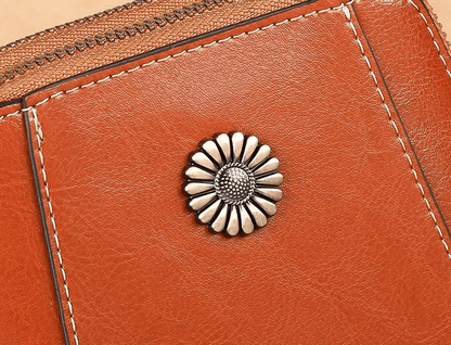 Close-up of the silver daisy-shaped stud and contrast stitching on tan leather 4