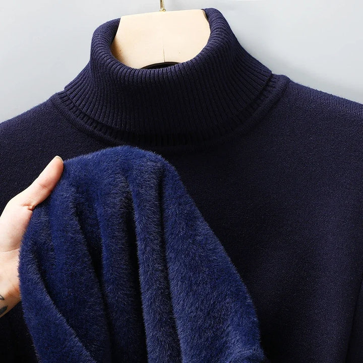 Navy turtleneck jumper on a hanger, with a hand showing the plush blue fleece lining inside 7