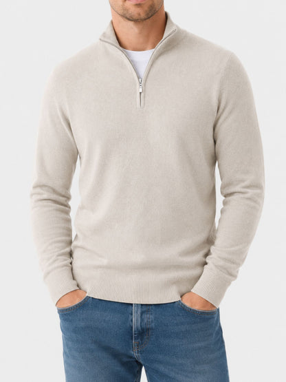 Model standing with both hands in jeans pockets wearing the cream half-zip jumper, front view showing the ribbed cuffs and hem. 10
