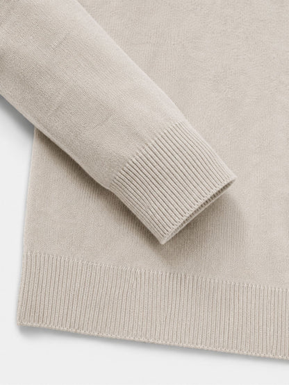 Detail of the cream jumper's ribbed cuff and hem, showing the fine knit texture of the sleeve and body. 15