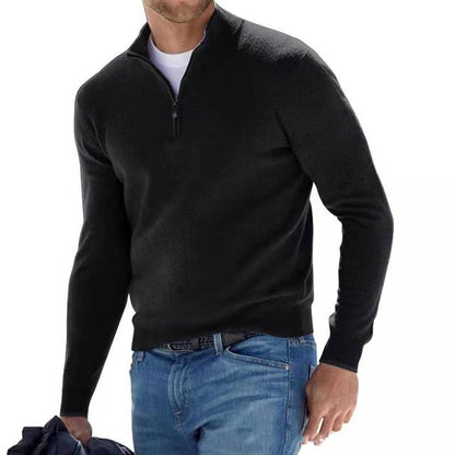 Model walking in the jumper in black with a half zip, worn over a white tee and blue jeans. 6