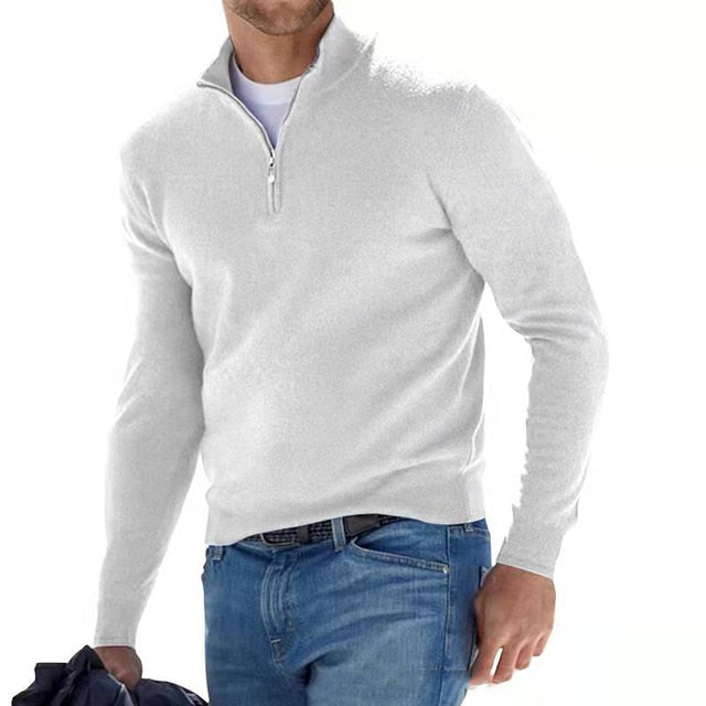 Model walking in the jumper in white with a half zip, worn over a white tee and blue jeans. 7