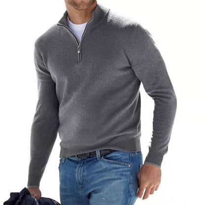Model walking in the jumper in dark grey with a half zip, worn over a white tee and blue jeans. 8
