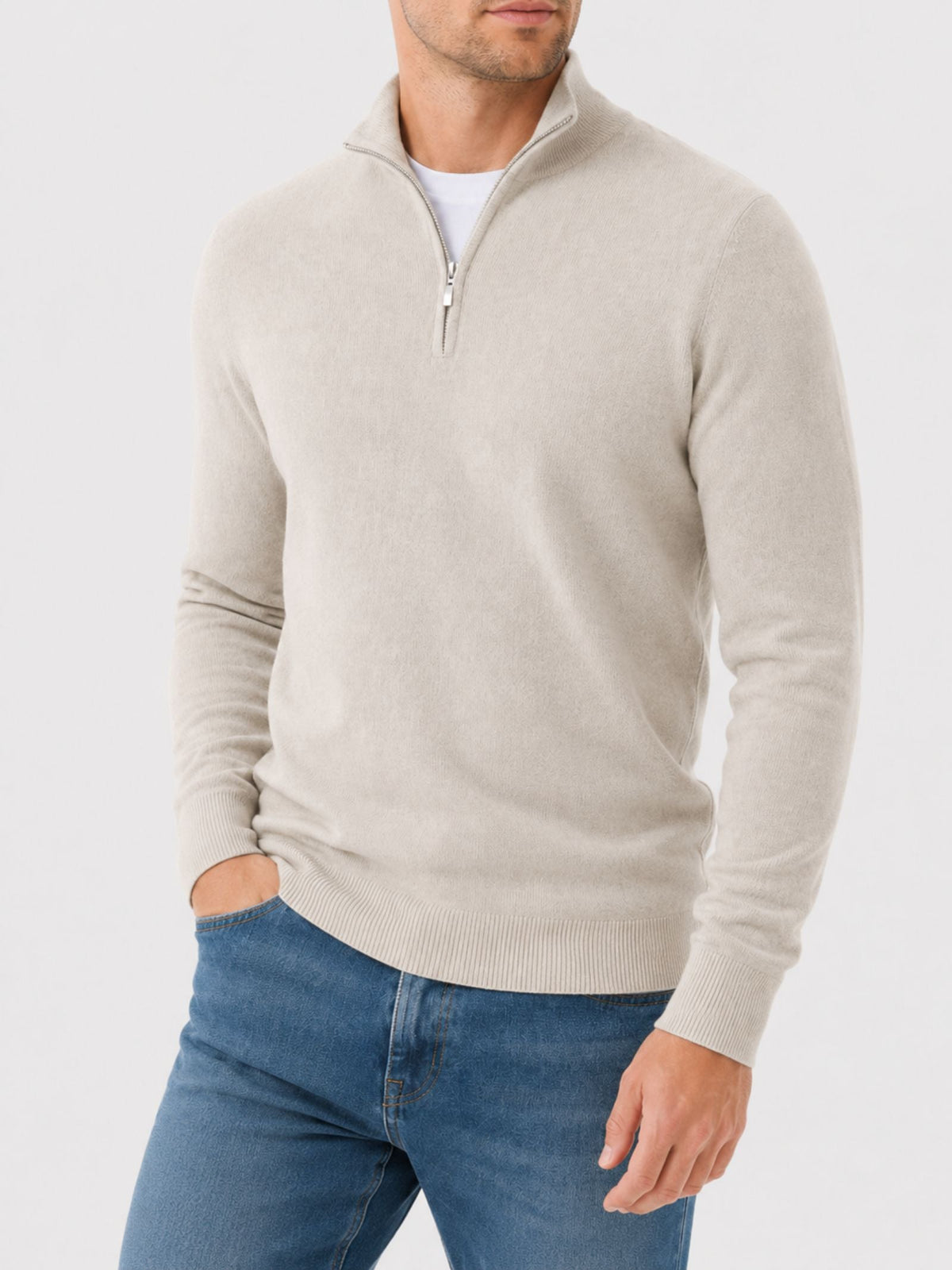 Model in the cream half-zip jumper from the front, one hand in a jeans pocket, showing the ribbed hem and cuffs. 9